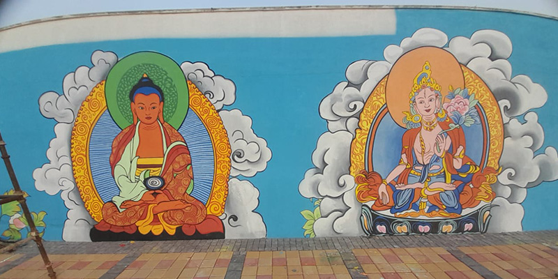 Two Buddha paintings grace the exterior of a building, highlighting their peaceful imagery and artistic craftsmanship.